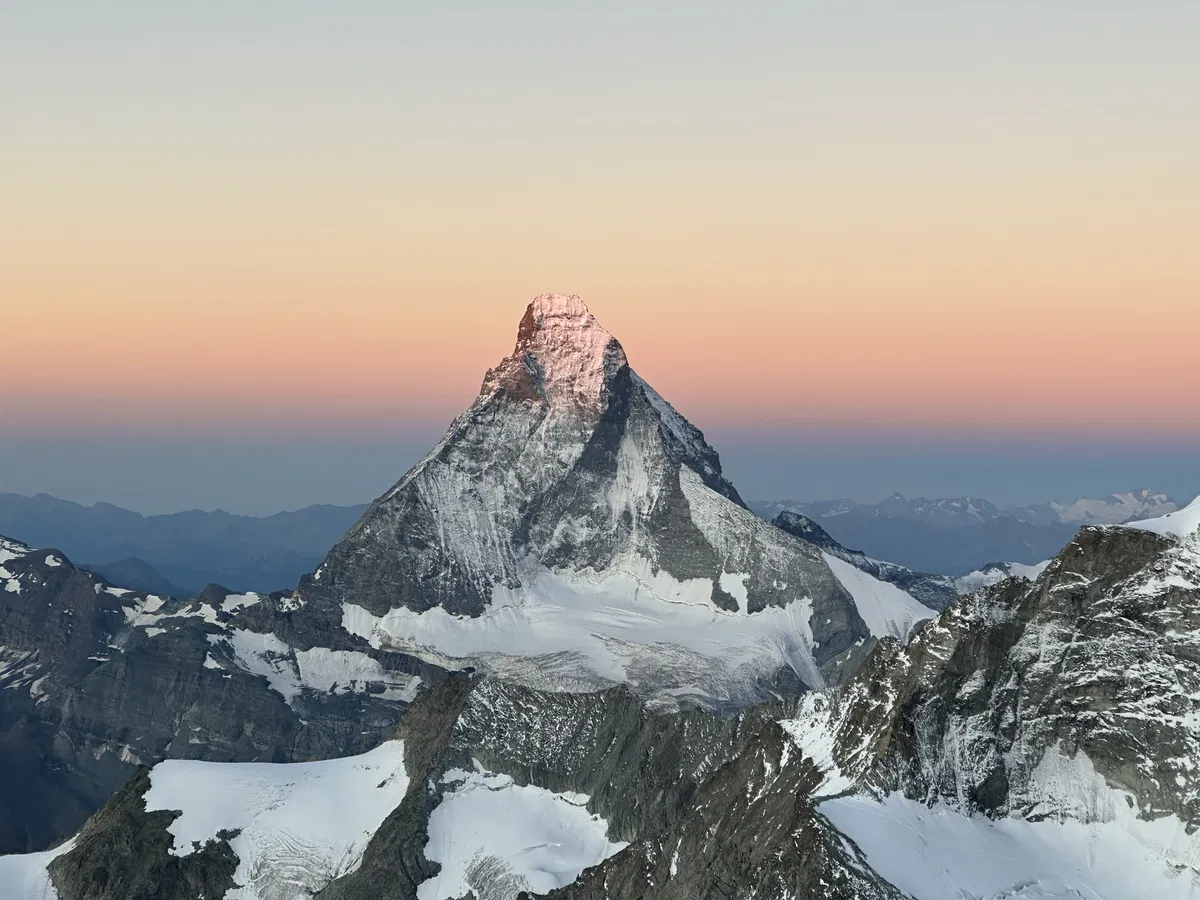Matterhorn erstrahlt im Morgenrot. Besteigung mit Bergfuehrer
